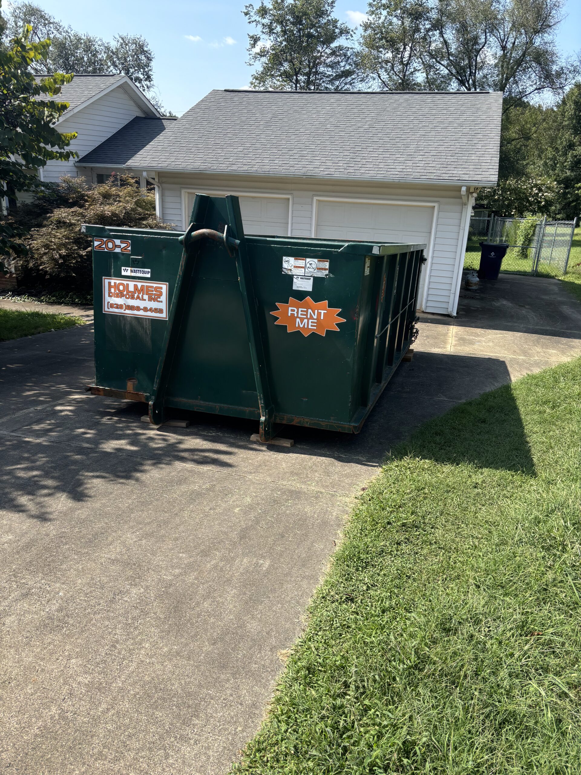 Green dumpster in Salem, NC in driveway