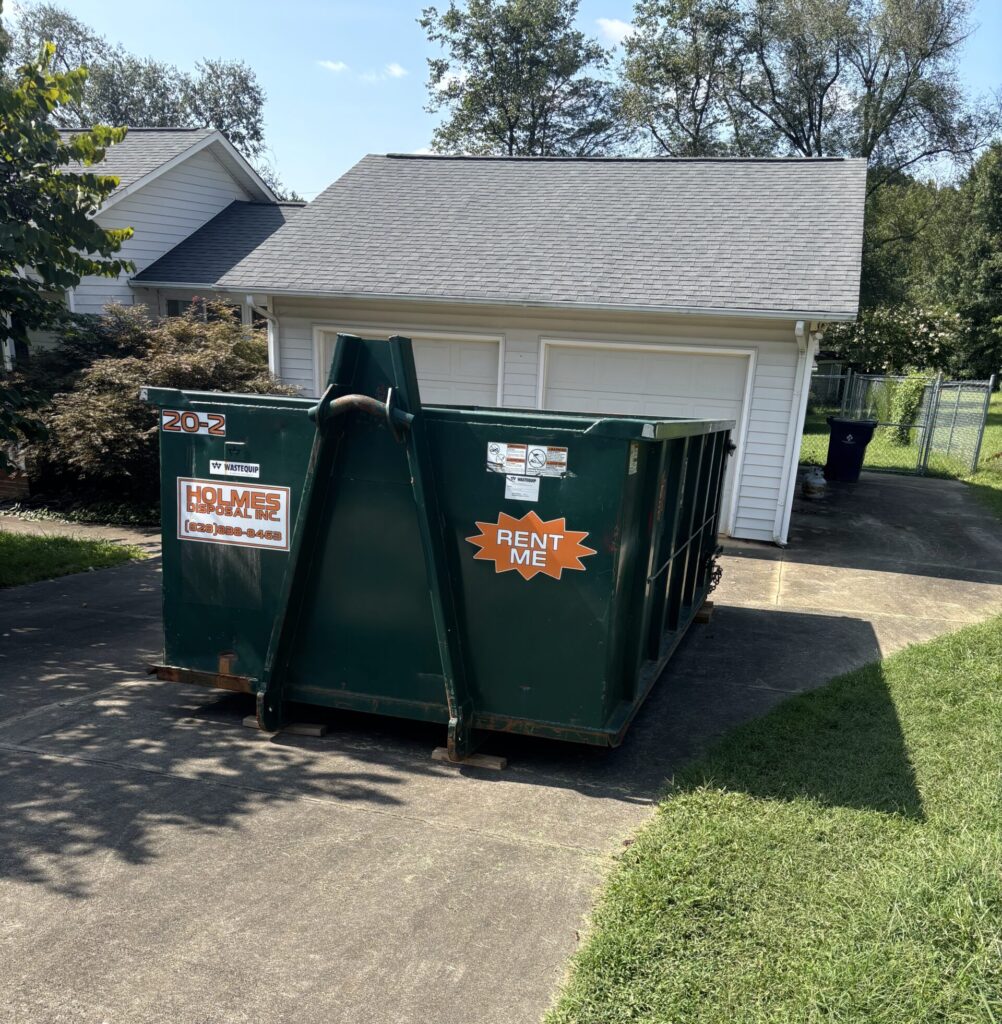 Green dumpster in Salem, NC in driveway