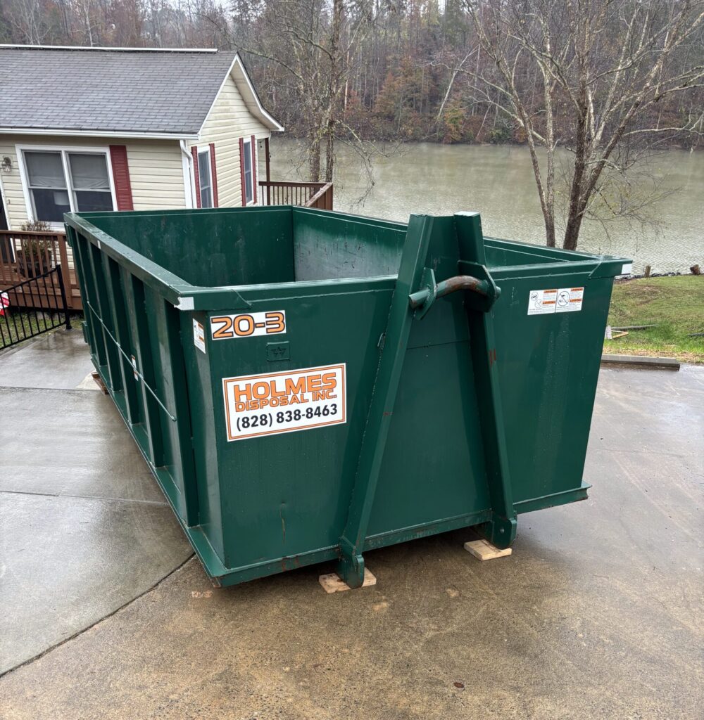 Green dumpster in Conover, NC on a driveway