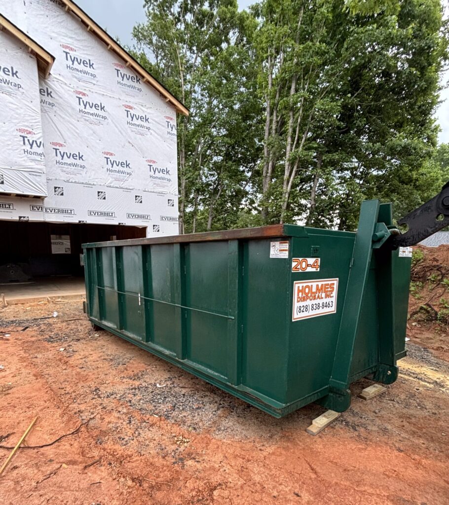Green dumpster in Catawba, NC on an unpaved driveway