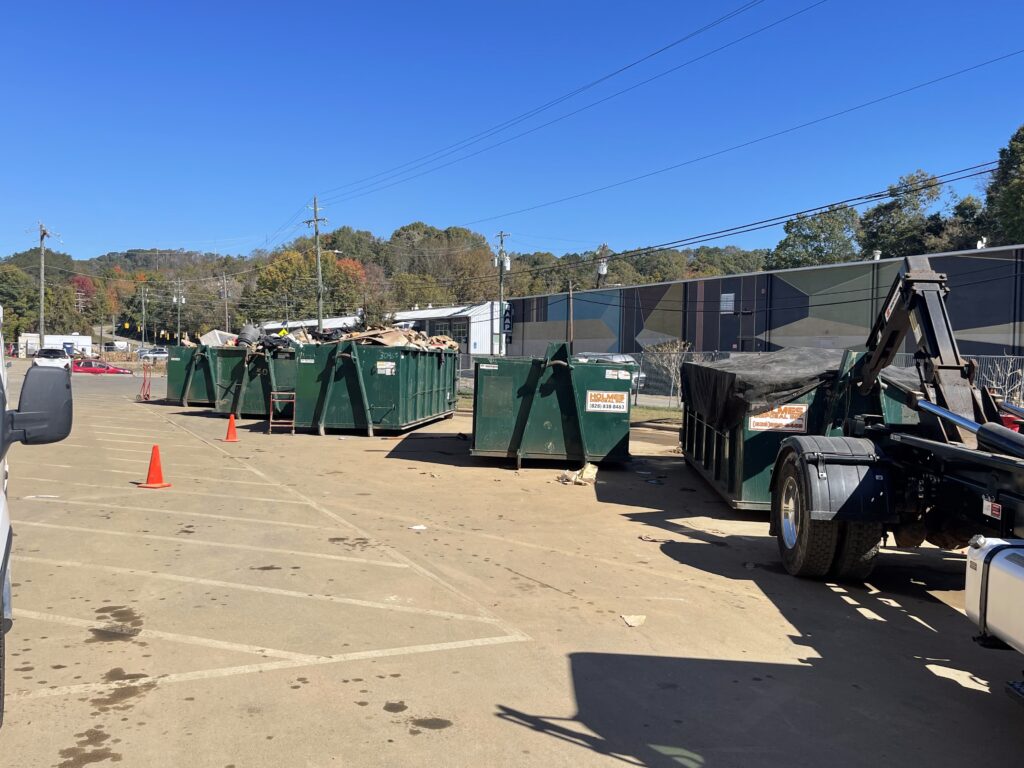 Green dumpsters in Catawba, NC in a parking lot